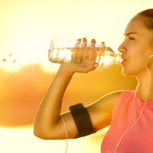 Mujer haciendo ejercicio y tomando agua