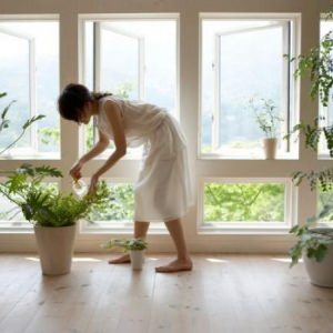 Mujer cuidando las plantas de su casa.